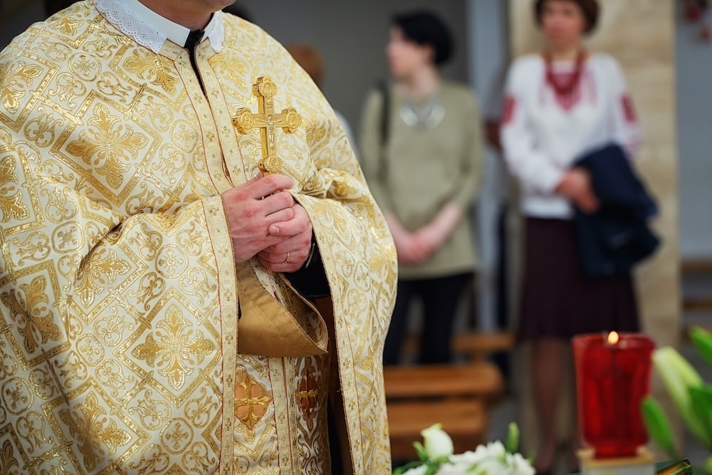 golden cross in male hands of priest