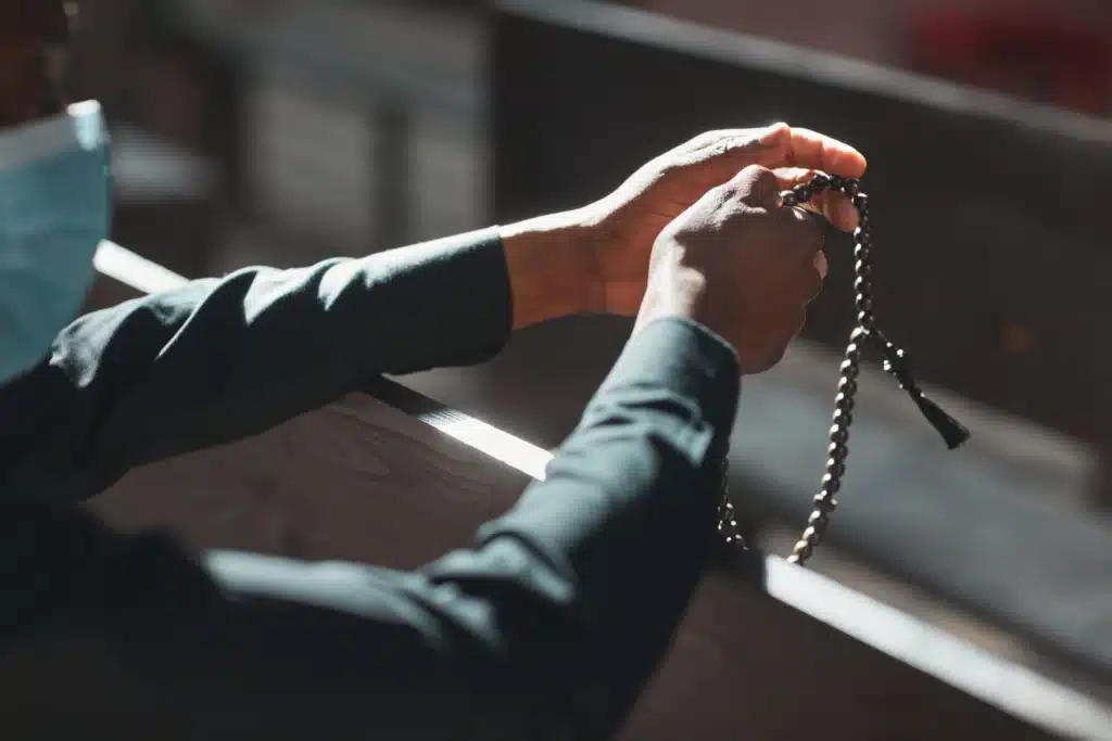 priest-holding-rosary-beads