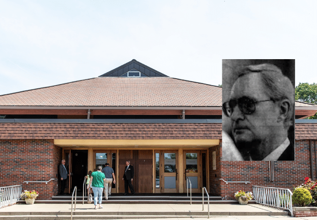 Portrait of Father Alfred Desrosiers displayed over exterior of St. Joan of Arc Church.